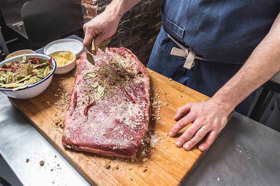Chef Luke coats beef brisket in seasoning to begin it's transformation into 12-day pastrami