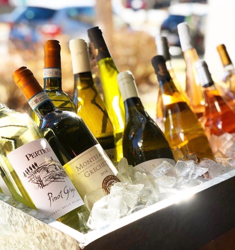 Patio ice box packed with white wine bottles
